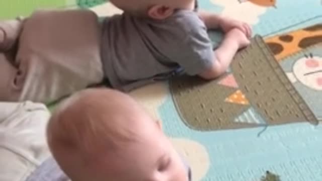 Twin babies adorably fall asleep at the same time