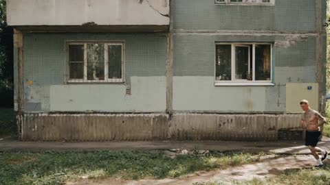 A Man Jogging In Front of an Old Building