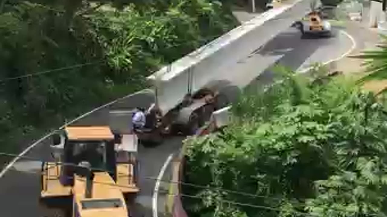 Skilled drivers navigate winding road with bridge beam
