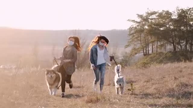 Two girls playing with dogs