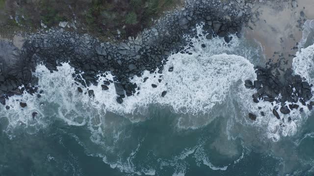 Top aerial shot of seashore with rocks