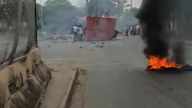 Protestors push a shipping container on the road in Durban