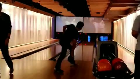 Guy falls in bowling alley after letting go of ball