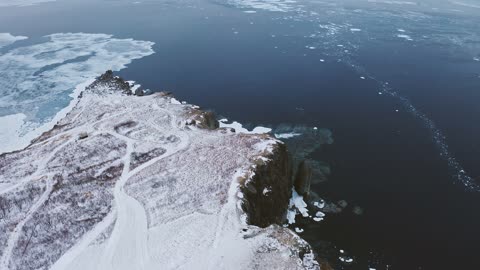 An Aerial Footage of a snow Covered Cliff