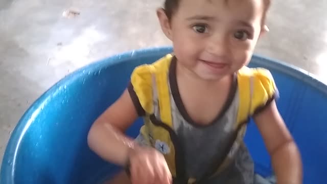 funny baby playing with water bucket