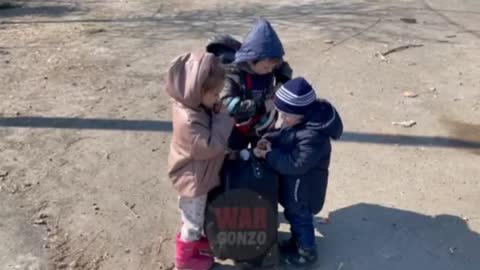 Ruští vojáci rozdávají dětem sladkosti v Mariupolu