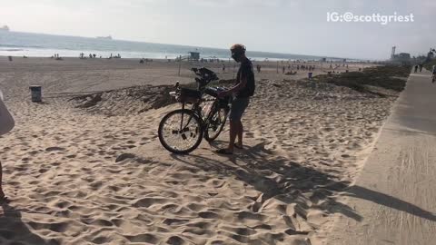 Man has dj booth on bike at beach