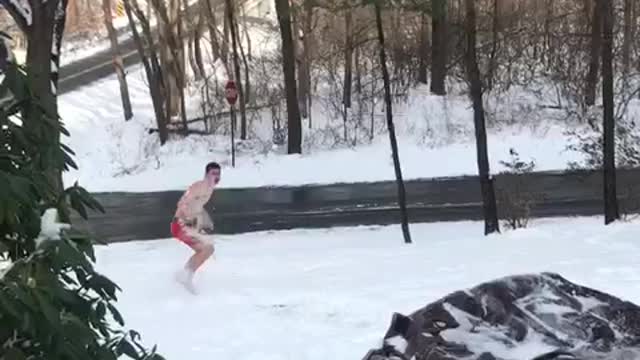 Guy in red underwear pouring water on himself and falling in snow