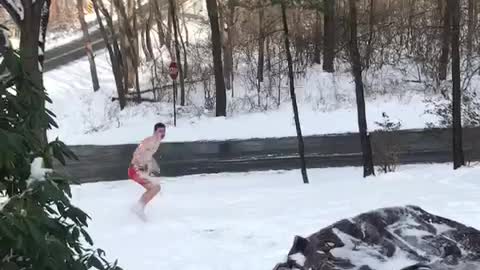 Guy in red underwear pouring water on himself and falling in snow
