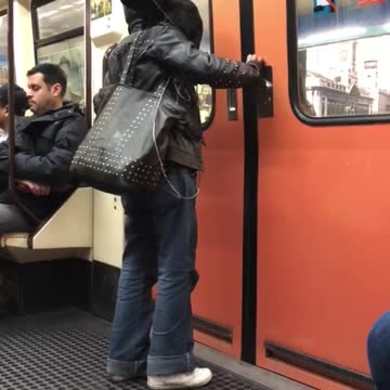 Woman with black cat on her shoulder can't wait to get out of subway train doors