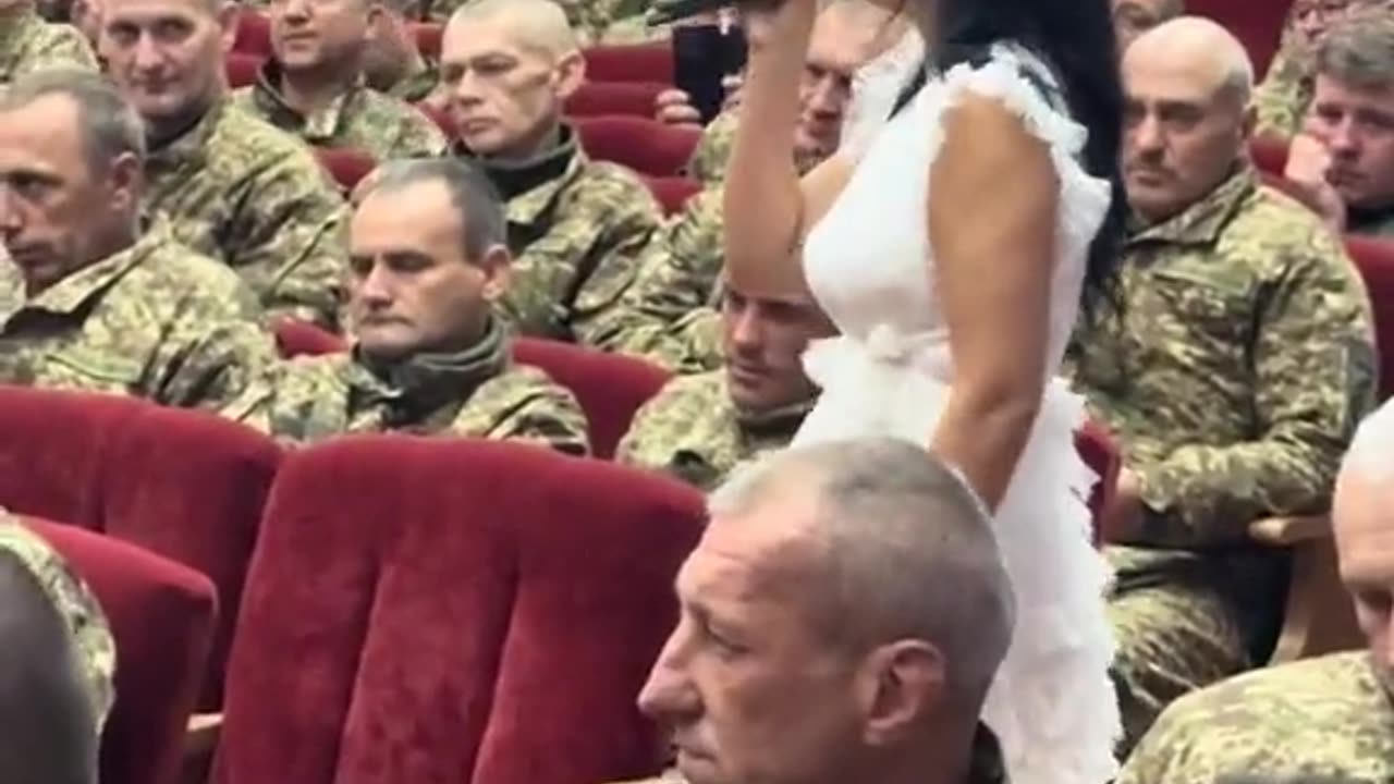 Grim older Ukrainian soldiers at rally before they depart
