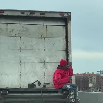 Man rides on back of truck to New York City