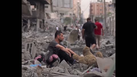 A Palestinian man sits in the middle of the ruins of his house,