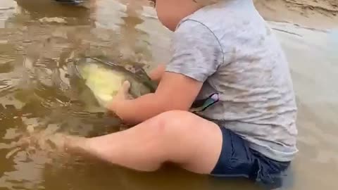 Tiny girl playing with a fish