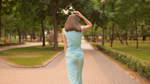 Girl dancing with her headphones while taking a walk