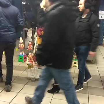 Man plays guitar at subway station with dancing dolls