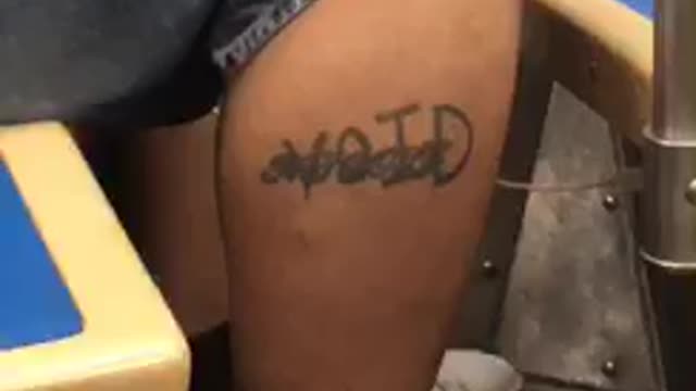 Man with divorced and void tattooed on leg is asleep