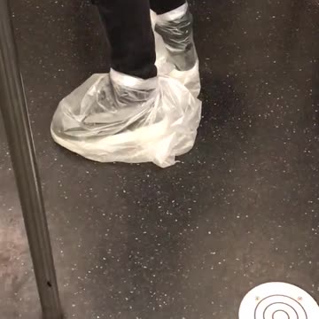 Person with plastic bags around shoes subway