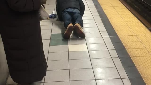 Man doing push ups next to train tracks