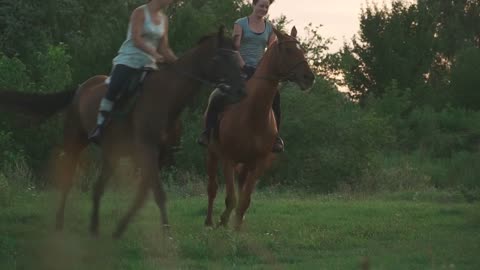 Two girls ride horses