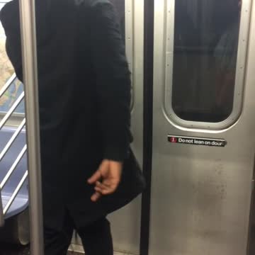 Backwards hat headphones guy dances in front of subway doors