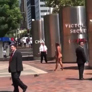 Naked mentally ill person walks around a business district while the rest of us ignore her.