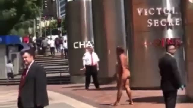 Naked mentally ill person walks around a business district while the rest of us ignore her.