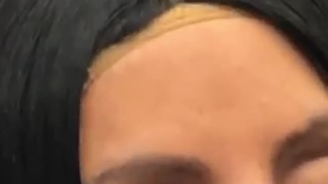 Sleeping woman wears an obvious long black wig on subway