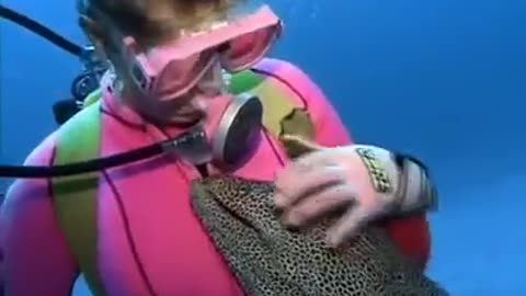 Girl fun with interesting fish in sea