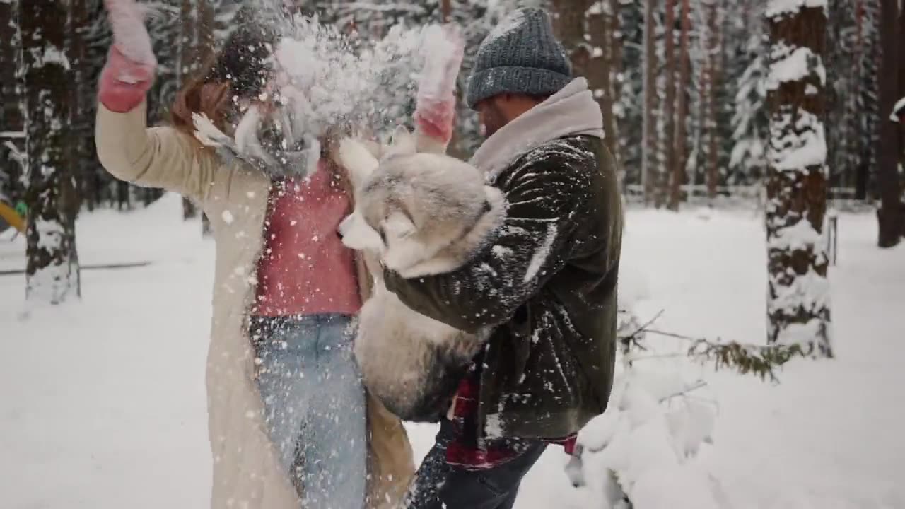 Man Carries His Dog While Playing In Snow