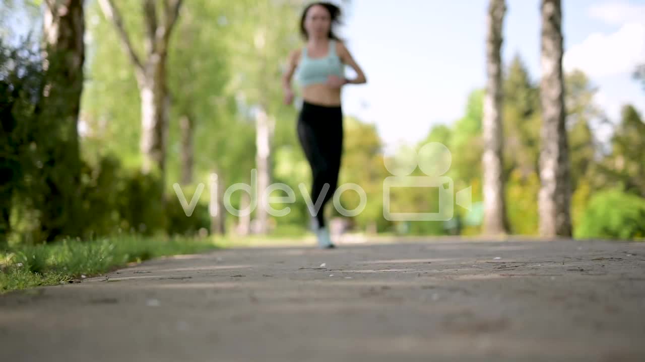 Sportswoman Running At The Park In A Sunny Day