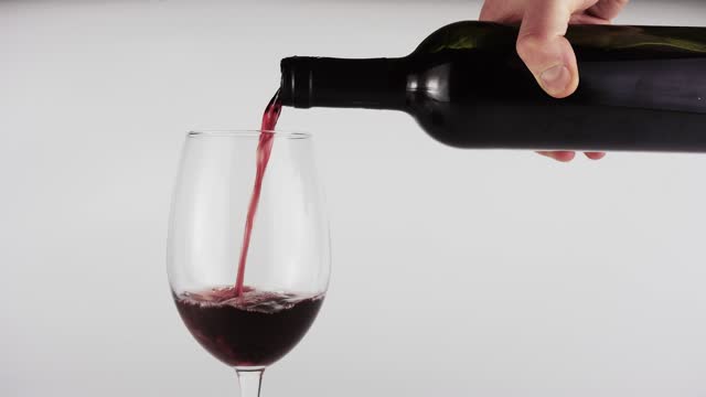 Red wine is poured into a glass.