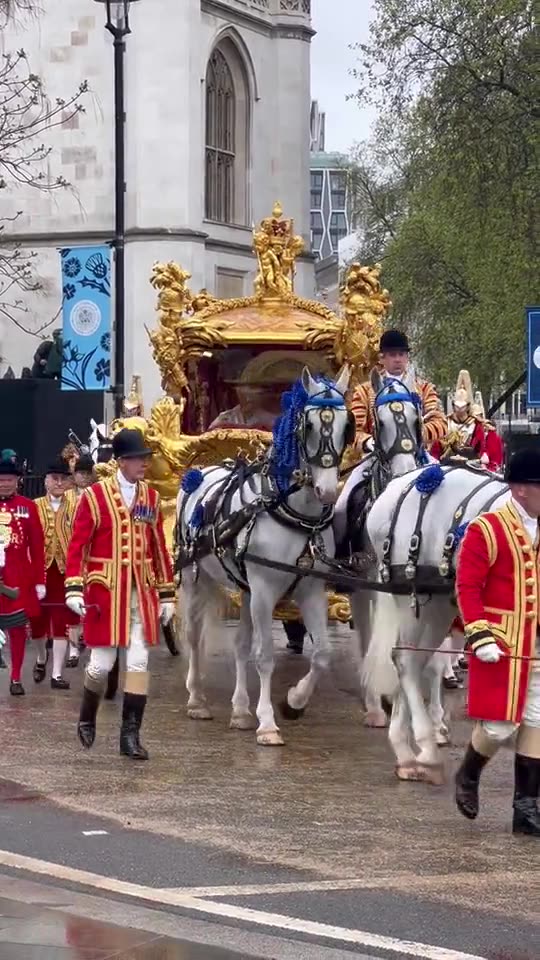 King Charles and Queen Consort Camilla greet onlookers during coronation procession