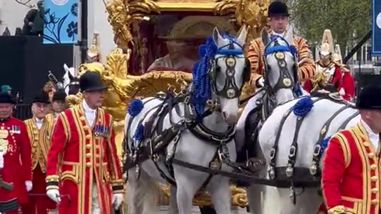 King Charles and Queen Consort Camilla greet onlookers during coronation procession