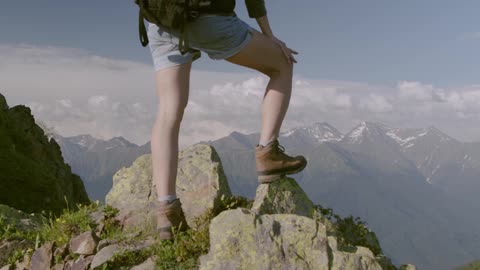 A Person Standing On Rocks Atop A Mountain