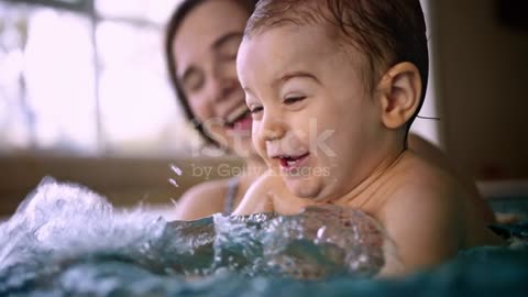 Baby laughing of happy cute baby splashing water playing with mother in pond