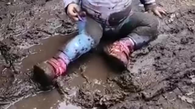 The child really enjoys playing in the mud