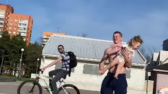 Toddler Holds One Leg Up While Balancing on Dad's Hand