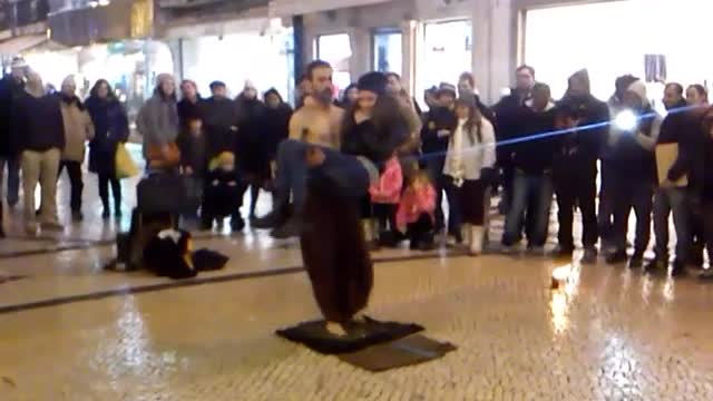 Street performer walks over broken glass