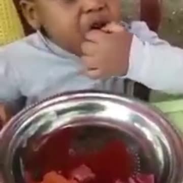 Kid eating uncooked meat. Amazing!