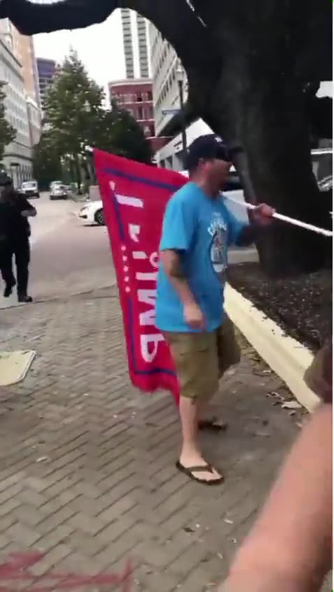 Hater spits on Trump flag, speeds off and then crashes into a pole.