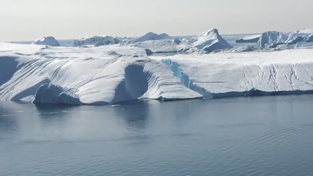 Ilulissat Icefjord - Large iceberg breaking over