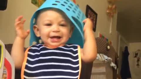 this baby puts the grocery basket on his head laughing