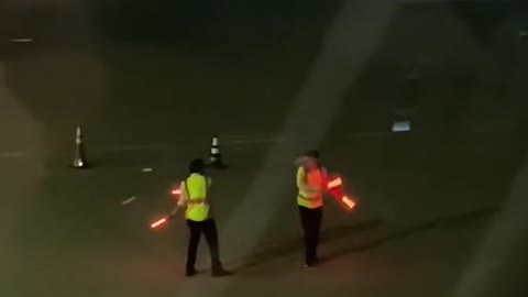 Airport marshalls entertain passengers on a delayed flight