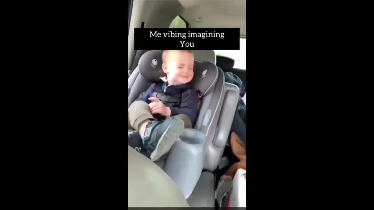Cute Baby in a good mood with the music in the car .