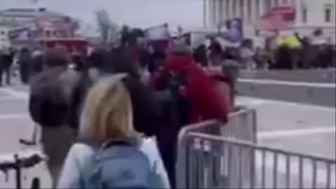 Americký policista ukazuje lidem, aby šli dál a zve je do Kongresu