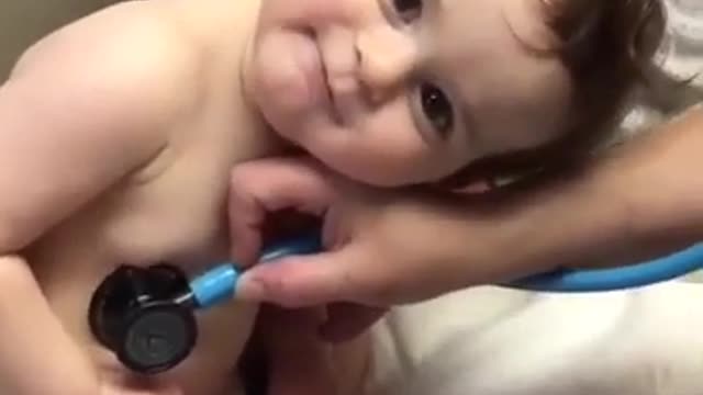 Baby lays in nurse's hand during exam