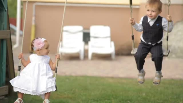 Boy And Girl On The Swings.