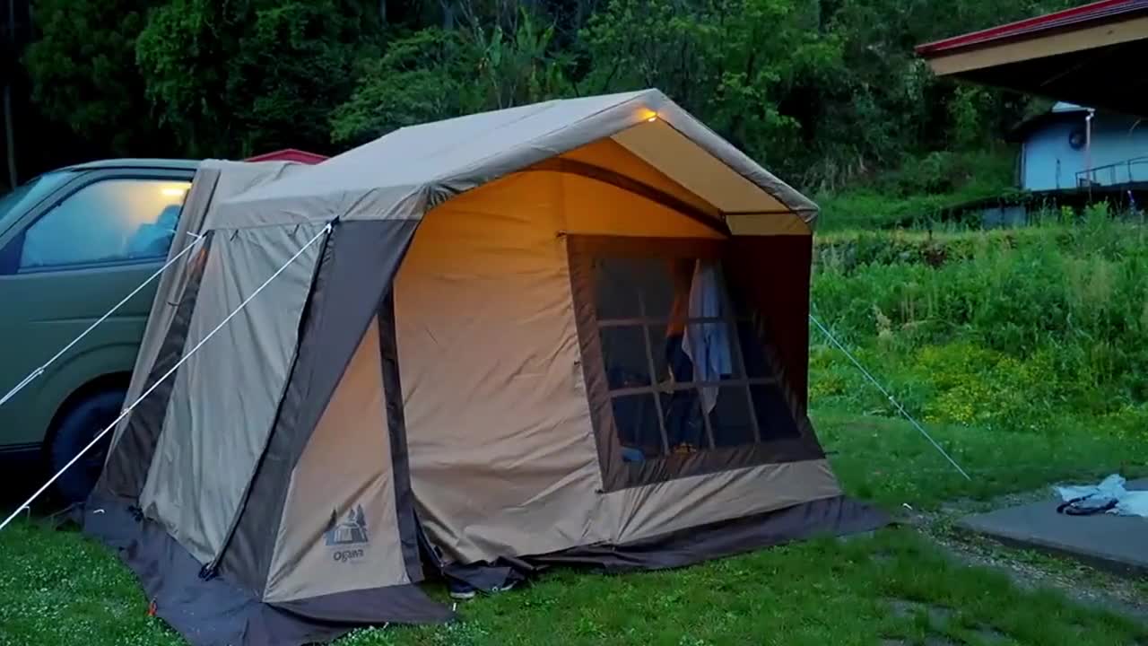 A family with three people camping in the rain