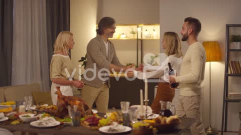 Wife And Husband Welcome Their Son And Daughter In Law Into In Living Room To Celebrate Thanksgiving